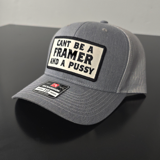 Gray cap with a black and white patch on a dark surface